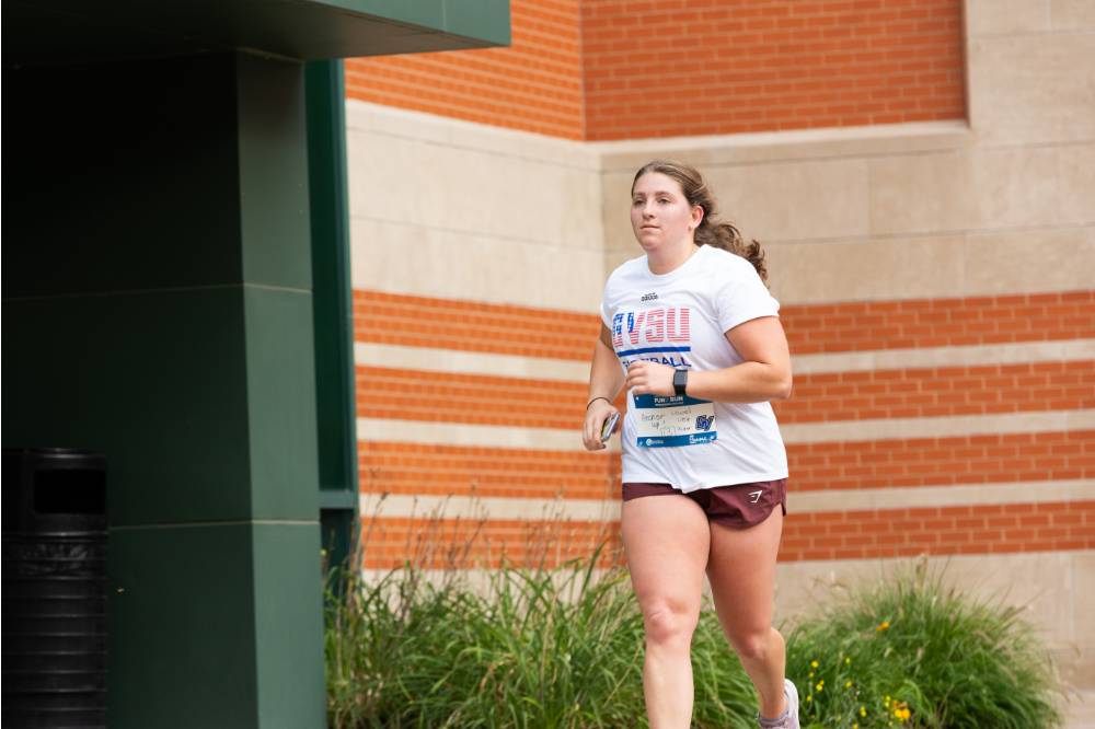 Participant nearing finish line wearing GVSU shirt